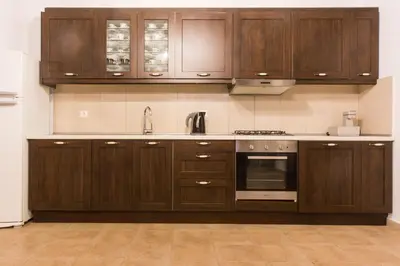 a kitchen with wooden cabinets and a sink at Roccia di Isidoro in Áyios Isídhoros