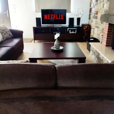 a living room with a couch and a tv at Roccia di Isidoro in Áyios Isídhoros