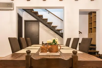 a dining room table with a vase of flowers on it at Roccia di Isidoro in Áyios Isídhoros