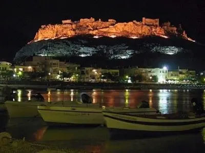 a group of boats sitting in the water at night at Haraki Bay Loft (by haris) in Haraki