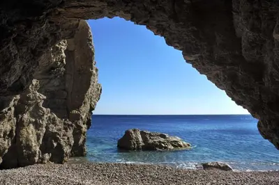 a view of the ocean through a rock cave at Haraki Bay Loft (by haris) in Haraki
