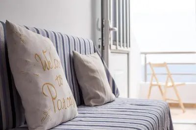 a blue couch with a pillow with the words happy new year at Haraki Bay Loft (by haris) in Haraki