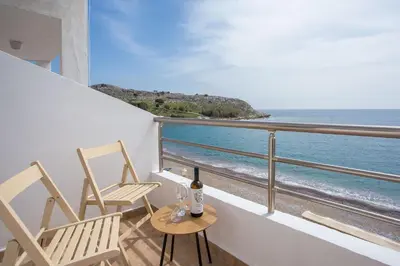 two chairs and a table on a balcony with the ocean at Haraki Bay Loft (by haris) in Haraki