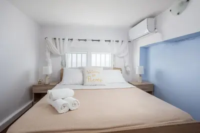 a bedroom with a large bed with towels on it at Haraki Bay Loft (by haris) in Haraki