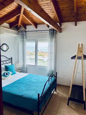 a bedroom with a blue bed and a ladder at Thalassia Avra Stegna Beach in Archangelos