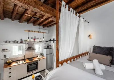 a bedroom with a bed and a small kitchen at Lotza Traditional House Salakos in Sálakos
