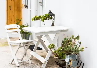 a white table with potted plants and a chair at Lotza Traditional House Salakos in Sálakos