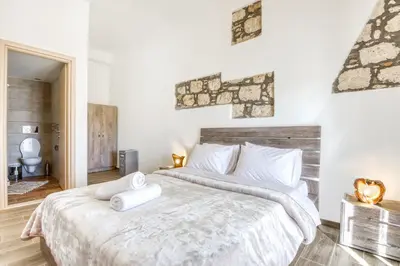 a bedroom with a large bed with white sheets at Villa Crypty in Soroni
