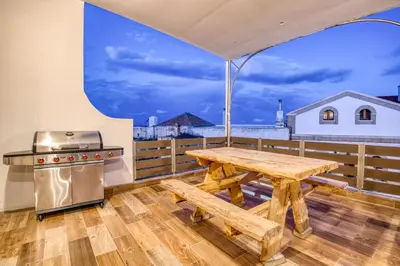 a picnic table and a grill on a balcony at Villa Crypty in Soroni