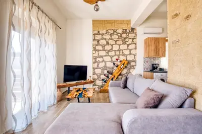 a living room with a couch and a stone wall at Villa Crypty in Soroni