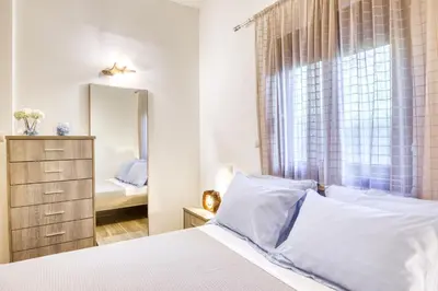 a bedroom with a white bed and a mirror at Villa Crypty in Soroni