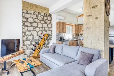 a living room with a couch and a stone wall at Villa Crypty in Soroni