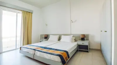 a bedroom with a bed and a large window at Lefteris Apartments in Ialysos Rhodes in Ialyssos