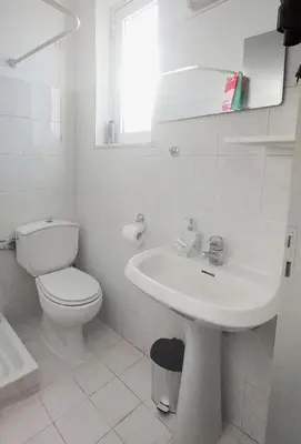a white bathroom with a toilet and a sink at Lefteris Apartments in Ialysos Rhodes in Ialyssos
