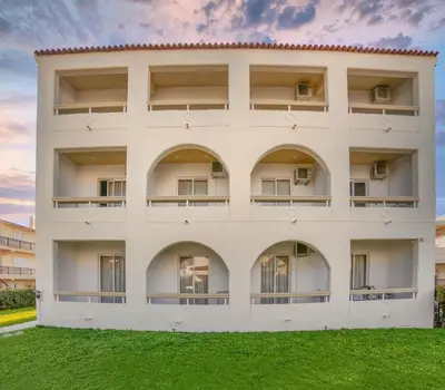 an apartment building with balconies and green grass at Lefteris Apartments in Ialysos Rhodes in Ialyssos