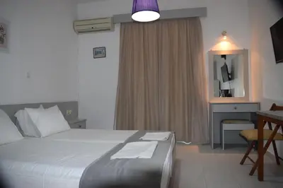 a bedroom with a bed and a desk and a mirror at Lefteris Apartments in Ialysos Rhodes in Ialyssos