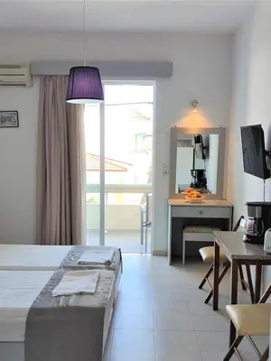 a bedroom with a bed and a table and a desk at Lefteris Apartments in Ialysos Rhodes in Ialyssos