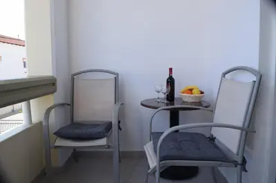 a table with two chairs and a table with a bottle of wine at Lefteris Apartments in Ialysos Rhodes in Ialyssos