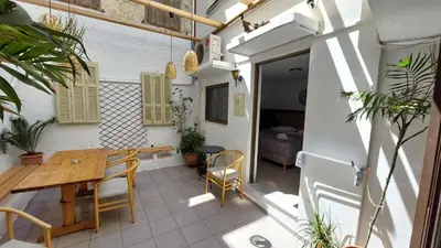 a balcony with a wooden table and chairs and a bedroom at OLD TOWN TALES apartments in Rhodes Town