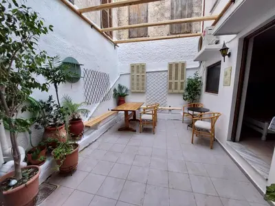 an outdoor patio with a wooden table and chairs at OLD TOWN TALES apartments in Rhodes Town