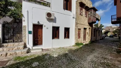 a white building with a wooden door on a street at OLD TOWN TALES apartments in Rhodes Town