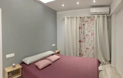 a bedroom with a purple bed with two pink pillows at RHODIAN TREASURE Spiridione apartment in Rhodes Town