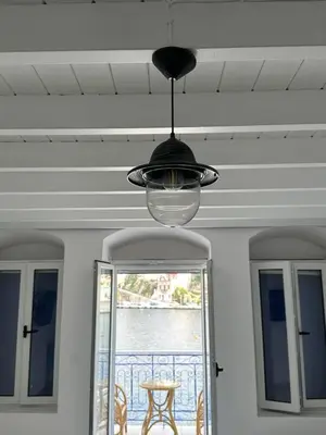 a black light hanging from a ceiling with a window at Cavo apartment in Symi