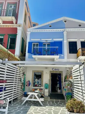 a store with a blue and white building at Cavo apartment in Symi