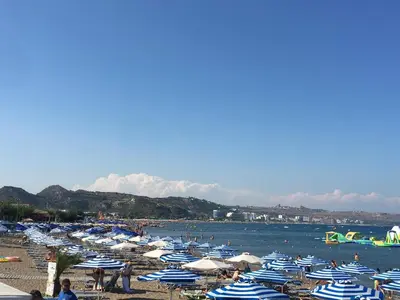 a beach filled with lots of blue and white umbrellas at RHODIAN TREASURE Spiridione studio 1 in Faliraki
