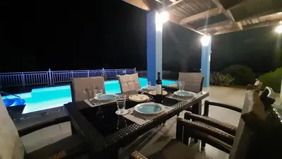 a table and chairs on a patio at night at Villa Selene in Archangelos