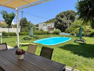 a table and chairs in a yard with a pool at Masefa villa in Ialyssos