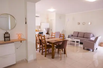a dining room and living room with a table and chairs at Masefa villa in Ialyssos