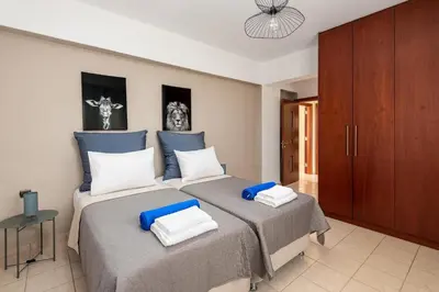 a bedroom with two beds with blue and white pillows at Aileen Villa in Koskinou