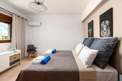 a bedroom with a bed with blue and white pillows at Aileen Villa in Koskinou