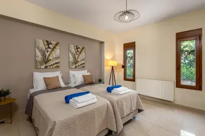 a bedroom with two beds with towels on them at Aileen Villa in Koskinou