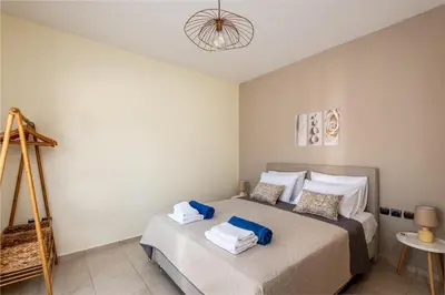 a bedroom with a bed with towels on it at Aileen Villa in Koskinou