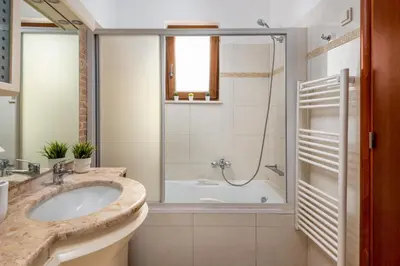 a bathroom with a tub and a sink and a shower at Aileen Villa in Koskinou