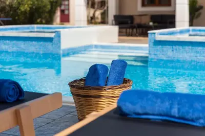 a basket of towels sitting next to a swimming pool at Aileen Villa in Koskinou