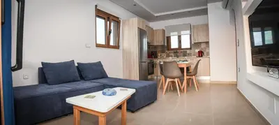 a living room with a blue couch and a table at Seaside Luxury Apartments Kremasti in Kremasti