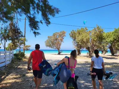 a group of people walking along the beach at Seaside Luxury Apartments Kremasti in Kremasti