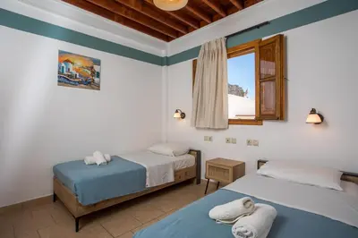 two beds in a room with a window at Villa Sakura in Líndos