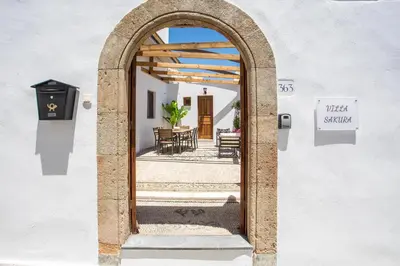 an archway leading to a patio with a table at Villa Sakura in Líndos