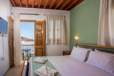 a bedroom with a bed and a door with a balcony at Villa Sakura in Líndos