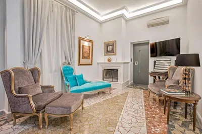 a living room with blue chairs and a fireplace at Arhondiko Apartment VS Rhodes Town in Rhodes Town