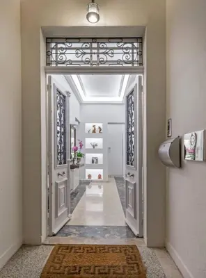 a hallway with an open door and a hallway with a rug at Arhondiko Apartment VS Rhodes Town in Rhodes Town