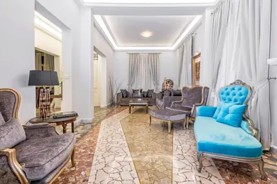 a living room with blue chairs and a couch at Arhondiko Apartment VS Rhodes Town in Rhodes Town