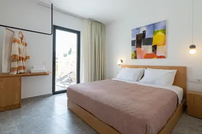 a bedroom with a large bed and a window at Nisi Living Concept in Ialyssos