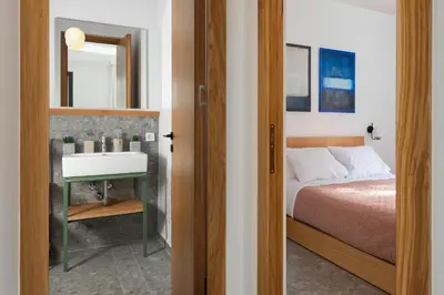 a bedroom with a bed and a sink and a mirror at Nisi Living Concept in Ialyssos