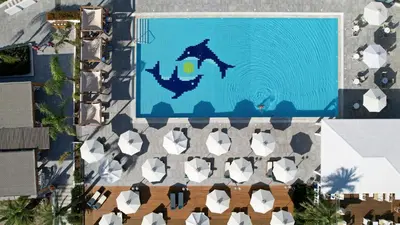 an overhead view of a swimming pool with chairs at Lindos Bay Hotel in vlicha