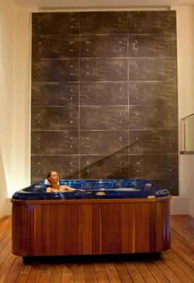 a woman in a jacuzzi tub in a room at Lindos Bay Hotel in vlicha
